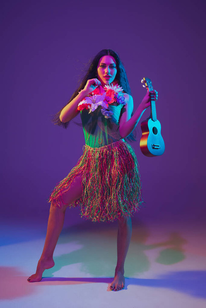 Fabulous Cinco de Mayo female dancer on purple studio background in neon light - Fotó, kép