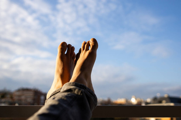 Stock photo of two feet againts the sky in the city. Relax pose. - Photo, Image