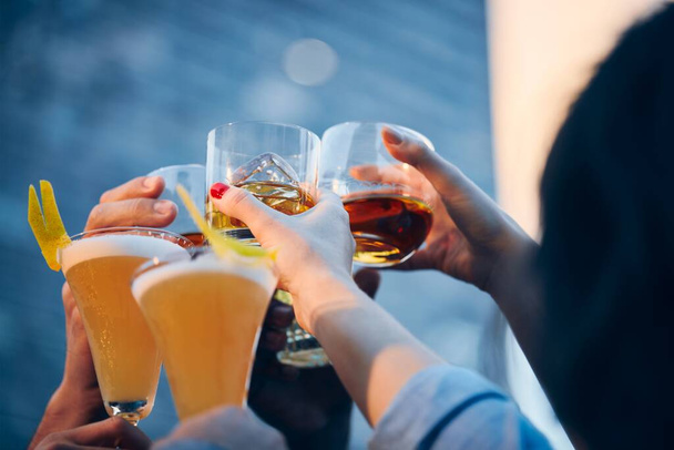 A closeup shot of many people clinking glasses with alcohol at a toast - Valokuva, kuva