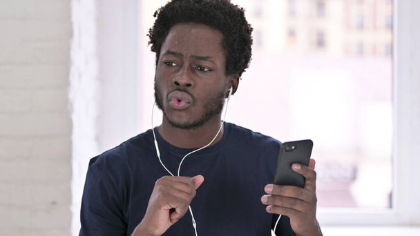 Retrato de un joven afroamericano escuchando música con auriculares
 - Foto, Imagen
