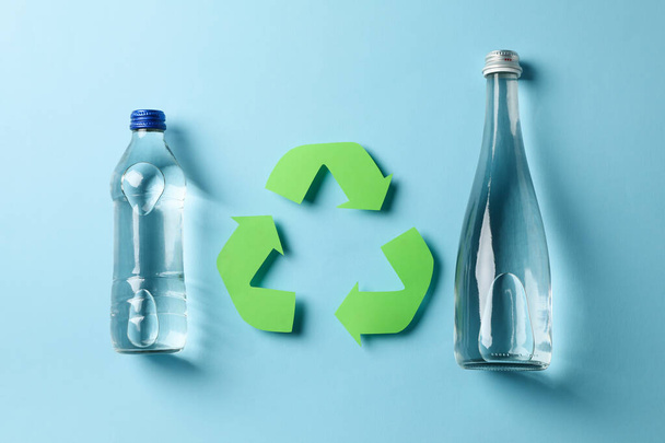 Eco concept met recycling symbool en flessen op blauwe achtergrond - Foto, afbeelding