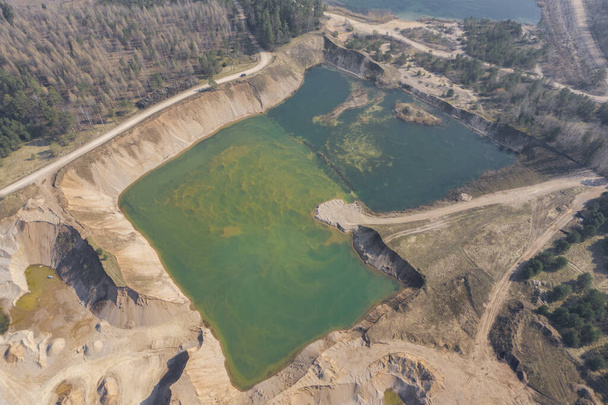 Letecký pohled na oplocený písek, štěrkový důl plný zelené vody - Fotografie, Obrázek