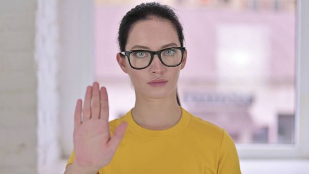 Πορτρέτο της επικεντρώθηκε νεαρή γυναίκα σχεδιαστής κάνει Stop Sign με το χέρι - Φωτογραφία, εικόνα