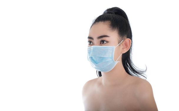 Mooie jonge Aziatische vrouw zet een medisch masker om te beschermen tegen luchtwegaandoeningen als de griep COVID-19 PM2.5 stof en smog, Vrouwen veiligheid virus infectie concept - Foto, afbeelding