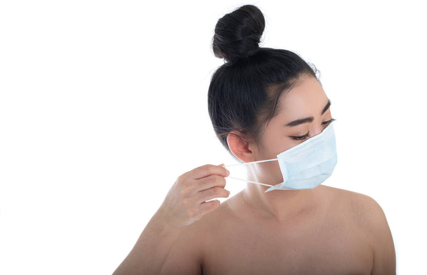 Hermosa mujer de Asia joven que se pone una máscara médica para proteger de las enfermedades respiratorias transmitidas por el aire como la gripe covid-19 PM2.5 polvo y smog, concepto de infección por virus de seguridad de las mujeres, mira cámara
 - Foto, imagen
