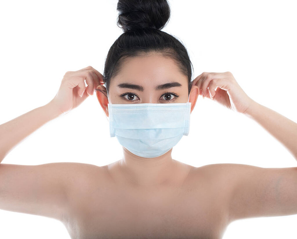 Krásná mladá asijská žena, která si nasazuje lékařskou masku na ochranu před vzduchem přenášenými onemocněními dýchacích cest, jako je chřipka covid-19 PM2.5 prach a smog, Ženy bezpečnostní virus infekce koncepce, podívejte se kamera - Fotografie, Obrázek