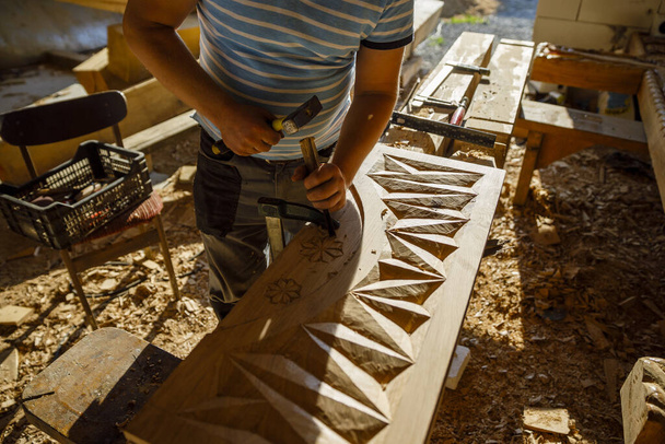 άνθρωπος σκαλίζοντας παραδοσιακά μοτίβα από Maramures Ρουμανία στο ξύλο στο εργαστήριο ξυλογλυπτικής - Φωτογραφία, εικόνα