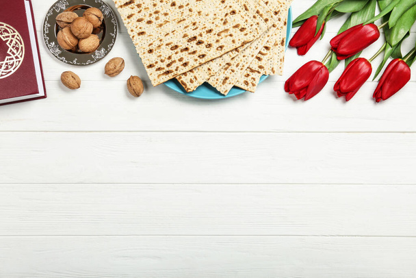 Flat lay composition with matzos on white wooden background, space for text. Passover (Pesach) celebration - Фото, зображення