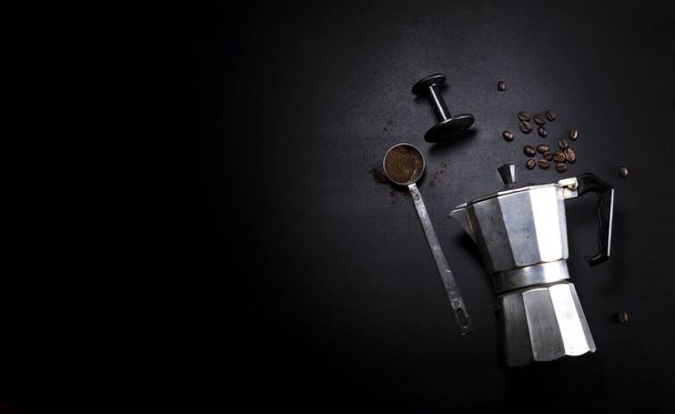 Kávéfőző és edények fekete háttérrel, szövegmásolási hellyel - Fotó, kép
