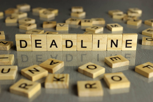 word deadline is made of square wooden letters on a gray background - Photo, image