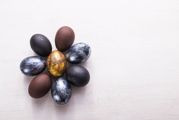 Свята, традиції та концепція Великодня - темні стильні великодні яйця на білому дерев'яному фоні з копіспадом
. - Фото, зображення