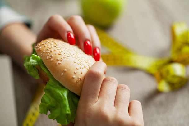 Mulher faz uma escolha entre alimentos nocivos e saudáveis - Foto, Imagem