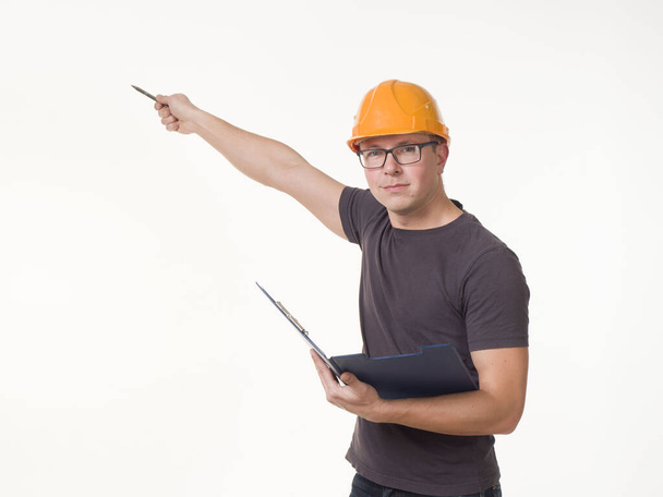 young man - worker in a helmet with a folder - Fotoğraf, Görsel