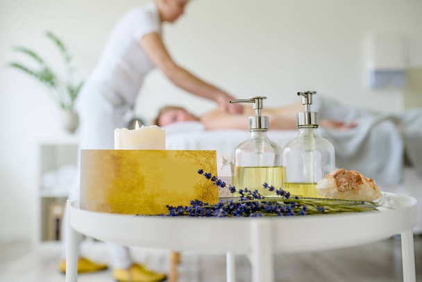 beauty salon, massage for woman and table with oils - Foto, Bild