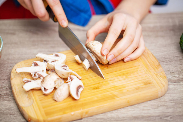 Closeup of woman slices mushrooms for diet salad - Fotoğraf, Görsel
