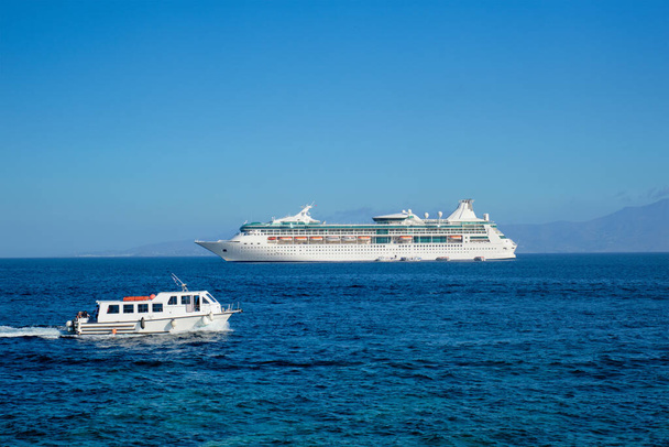 ボートとクルーズライナーはエーゲ海です。ギリシャミコノス島チョーラ島 - 写真・画像