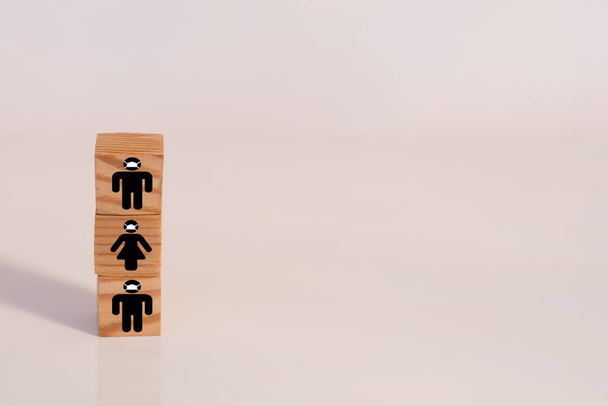 Wooden cubes with the image of silhouettes of men and women in protective masks. Healthcare and medical, Environmental pollution concept. - Photo, Image