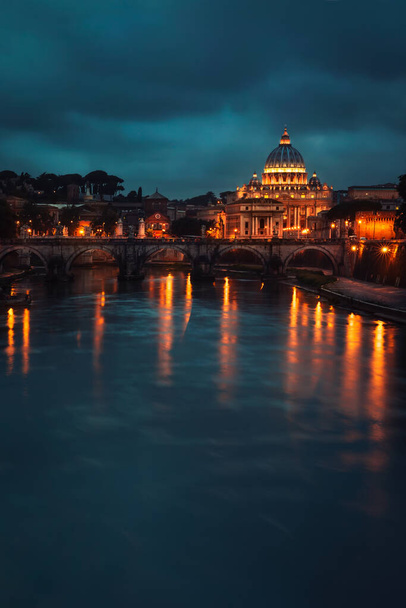 Beautiful night view on St. Peter's Basilica, glowing lights of the church reflected in the river, amazing European architecture of Italy, Rome, Vatica - Photo, image