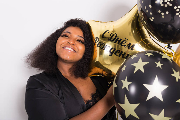 Vacaciones, fiesta de cumpleaños y concepto de diversión - Retrato de la joven mujer joven afroamericana sonriente con estilo en el fondo blanco celebración de globos
. - Foto, imagen