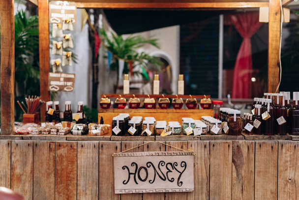 Wooden counter with glass jars of honey - Fotoğraf, Görsel