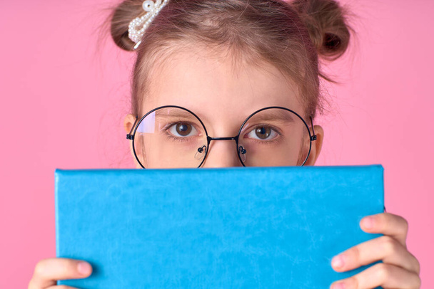 Portrait of her she nice foxy lovely attractive cheerful positive school girl holding in hands hiding behind opened book exam preparation isolated over pink background - Fotoğraf, Görsel