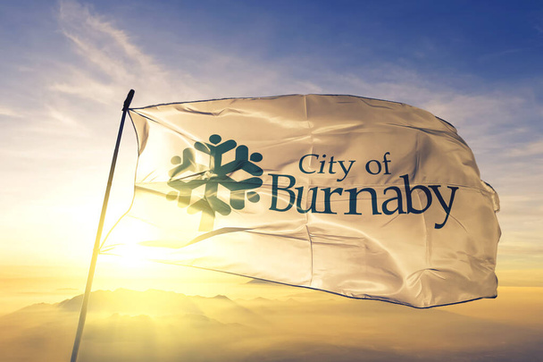 Burnaby of British Columbia of Canada Прапор текстильної тканини тканини, що махає на тумані сонця - Фото, зображення