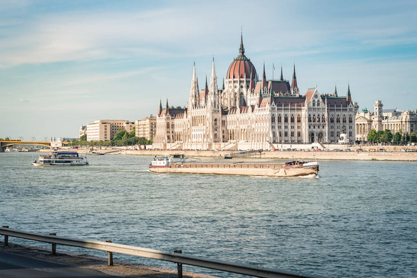 日没時のブダペスト議会。ハンガリーのドナウ川を渡る船 - 写真・画像