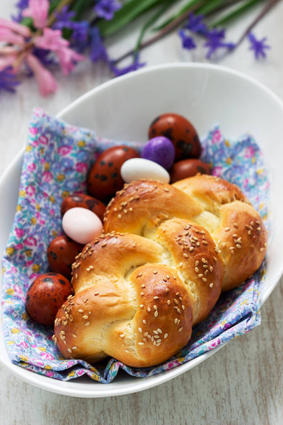 Pan de Pascua, huevos de colores y flores sobre un fondo blanco. Enfoque selectivo
. - Foto, Imagen