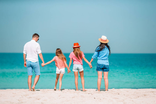 Фото счастливой семьи, развлекающейся на пляже. Летние каникулы - Фото, изображение