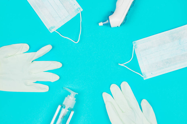 Maschera medica, termometro, guanti in lattice bianco e gel igienizzante per le mani su sfondo blu
. - Foto, immagini