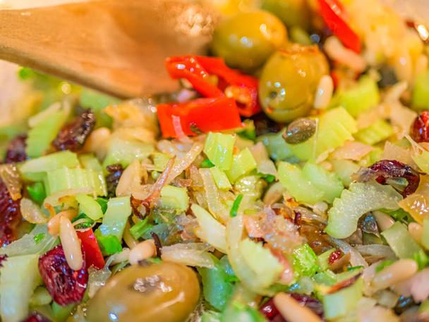 Sauted cod with tomato, raisins, pine nuts, celery, red onion, oil, pepper and olives and olives. - Photo, Image