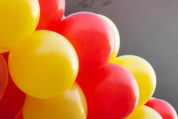 Žluté a červené balónky na budově zblízka - Fotografie, Obrázek