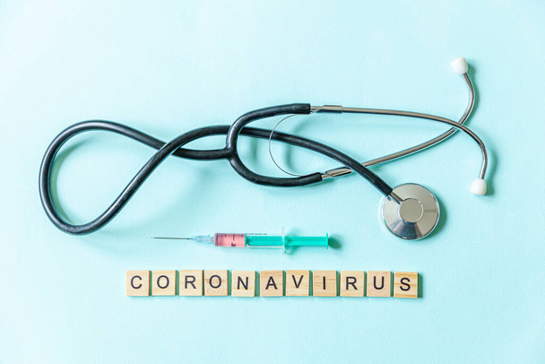 Mavi pastel arka planda Coronavirus şırıngası ve steteskop. Roman Coronavirus 2019-nCoV MERS-Cov Covid-19 Orta Doğu Solunum Sendromu Coronavirus virüs aşısı konsepti - Fotoğraf, Görsel