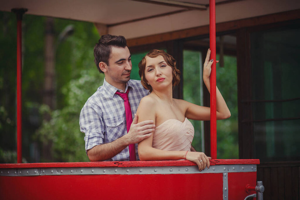 A guy and a girl in retro clothes vintage hairstyles are standing at the railing of the tram - Φωτογραφία, εικόνα