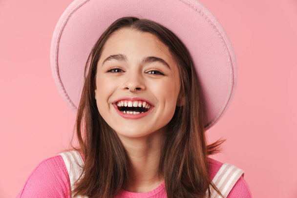 Photo of lovely charming girl in hat laughing and posing at camera isolated over pink background - Fotó, kép