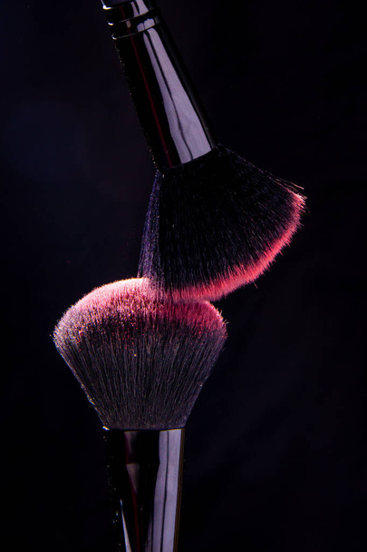 Cosmetic brushes in a bright palette of powder. Colorful explosion under makeup. - Foto, Imagem