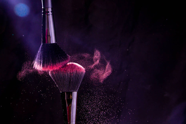 Cosmetic brushes in a bright palette of powder. Colorful explosion under makeup. - Foto, afbeelding