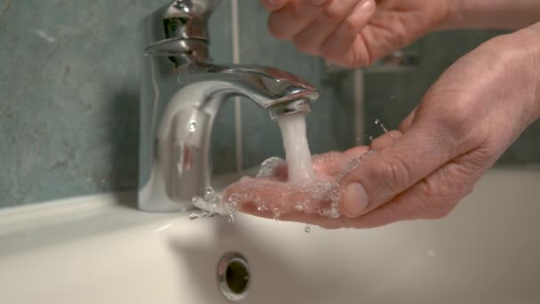 Κοντινό πλάνο, DOF: αγνώριστο άτομο ανοίγει τη βρύση και πλένει τα χέρια του. - Πλάνα, βίντεο