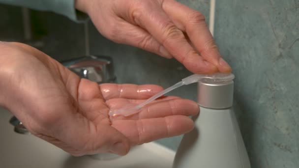 Η γυναίκα πλένει υγρό σαπούνι στην παλάμη της για να απολυμάνει τα χέρια της. - Πλάνα, βίντεο