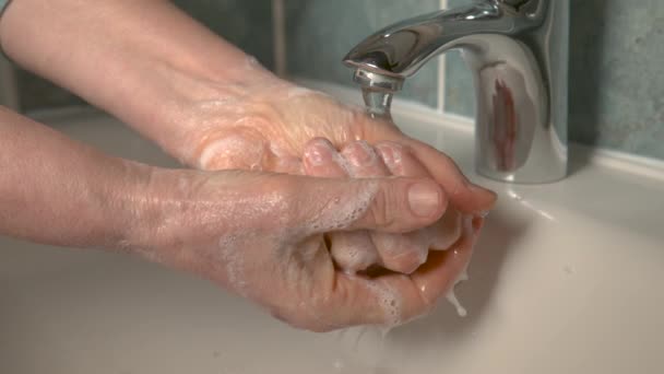 Κοντινό πλάνο, DOF: αγνώριστη ηλικιωμένη γυναίκα πλένει τα χέρια της με σαπούνι και νερό. - Πλάνα, βίντεο