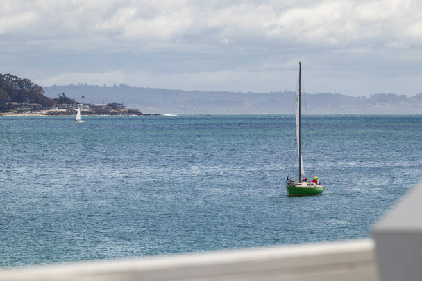 Sail Boat Returns in Harbor. A green sail boat arrives in a harbor, approaches a pier in Santa Cruz, California. - Photo, Image