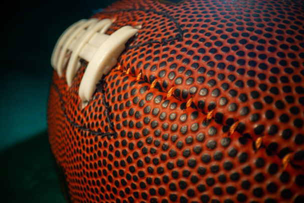 Extreme Weitwinkel-Makro-Nahaufnahme auf den genähten Schnürsenkeln, der strukturierten Haut und den Grübchen eines American Football. - Foto, Bild