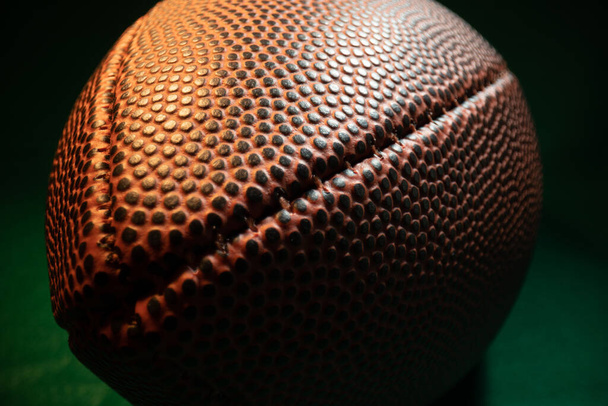 Extreme Weitwinkel-Makro-Nahaufnahme auf den Nähten, strukturierte Haut und Grübchen eines American Football. - Foto, Bild