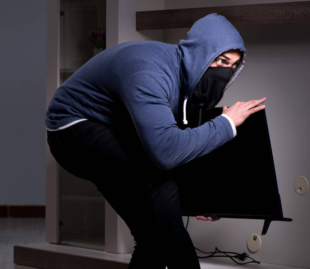 Ladrão ladrão roubando tv de casa de apartamento - Foto, Imagem