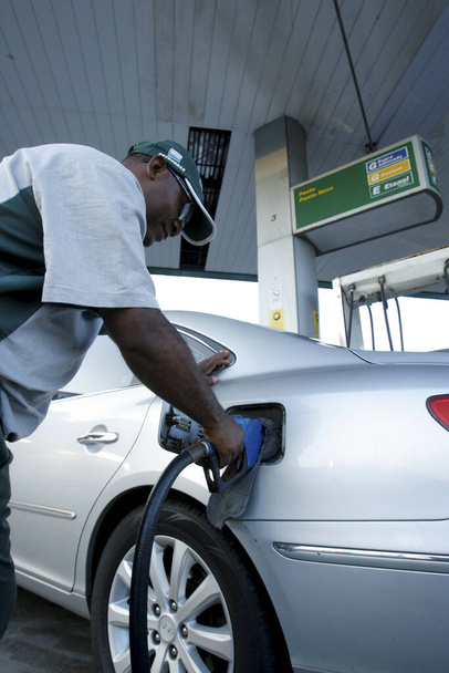 salvador, bahia / brazil - december 10, 2012: gas station attendant is seen filling up a vehicle at petrol stations in the Petrobras network, in the city of Salvador. *** Local Caption *** - Foto, afbeelding