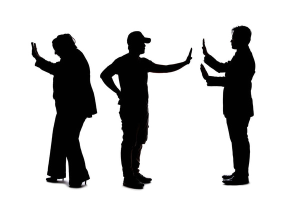 Silhouette of a group of people practicing social distancing which is recommended during virus pandemics to avoid infection.  Groups in public should keep a distance away from each other for safety - Photo, Image