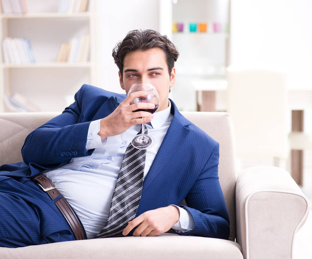 Businessman drinking wine sitting at home - Фото, зображення