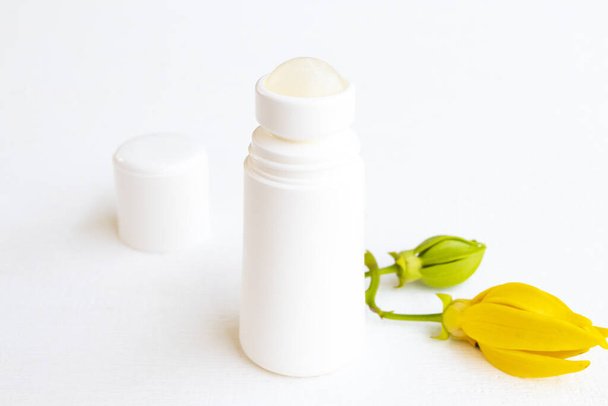 roll on dezodorant antiperspirant aromat kwiat ylang ylang opieka zdrowotna dla powierzchni pachy z żółtymi kwiatami ylang ylang układ płaski lay styl na tle biały  - Zdjęcie, obraz