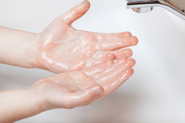 Das Kind wäscht sich im heimischen Badezimmer gründlich die Hände - Foto, Bild