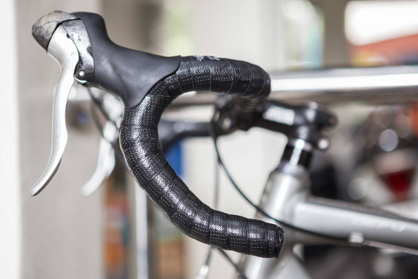 Enfoque selectivo de la manija de la bicicleta sobre fondo borroso con luz solar
 - Foto, imagen